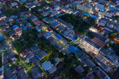Aerial view of local old residential neighborhood. A village in urban housing development from above. Top view. Real estate in urban city town. Property real estate at night.