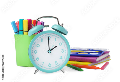 Turquoise alarm clock and different stationery on white background. School time