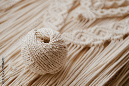 Bild auf Leinwand White natural cotton macrame cord in a roll on a handmade wall hanging