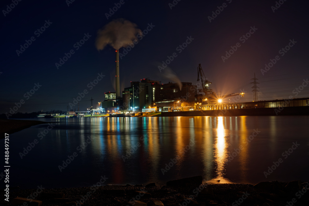 Large power plant Mannheim at night with reflection in the Rhine.