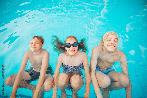 Children Having Fun In Outdoor Swimming Pool
