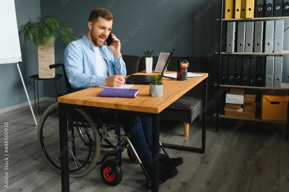 Man in wheelchair at home or in office. Man in wheelchair at home or in office.