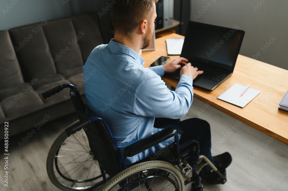 Young happy entrepreneur in wheelchair working on laptop at home. Young happy entrepreneur in wheelchair working on laptop at home.