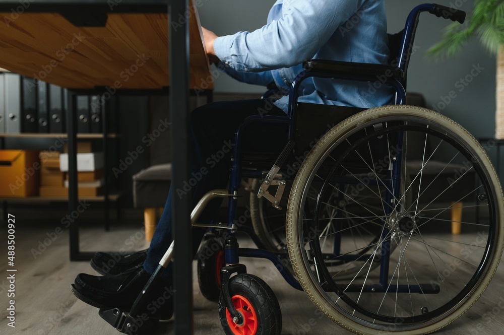 Obraz premium Man in wheelchair at home or in office.