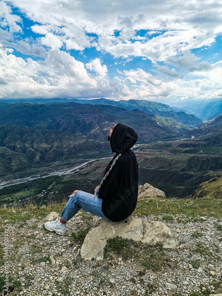 A girl on the background of a breathtaking view of the mountains in Dagestan, Caucasus. Russia 2021