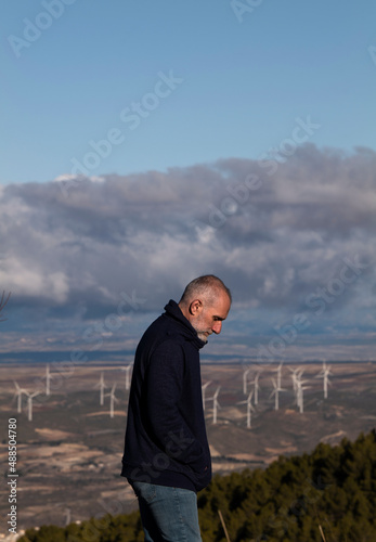 Portrait of adult man in field with modern windmills in background. Almeria, Spain