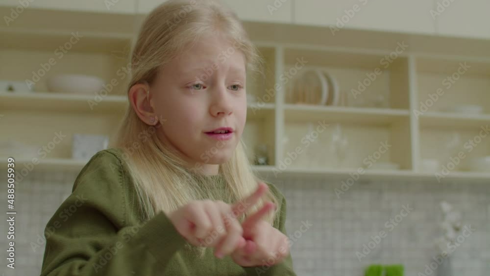 Portrait of lovely joyful preadolescent hearing impaired child communicating with sign language, talking and sharing with friends, expressing positive vibes, happiness and cheerful mood indoors. Portrait of lovely joyful preadolescent hearing impaired child communicating with sign language, talking and sharing with friends, expressing positive vibes, happiness and cheerful mood indoors.