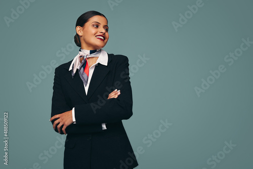 Cheerful stewardess smiling happily in a studio photo