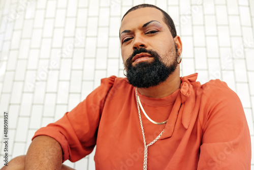 Young man looking at the camera while wearing drag photo