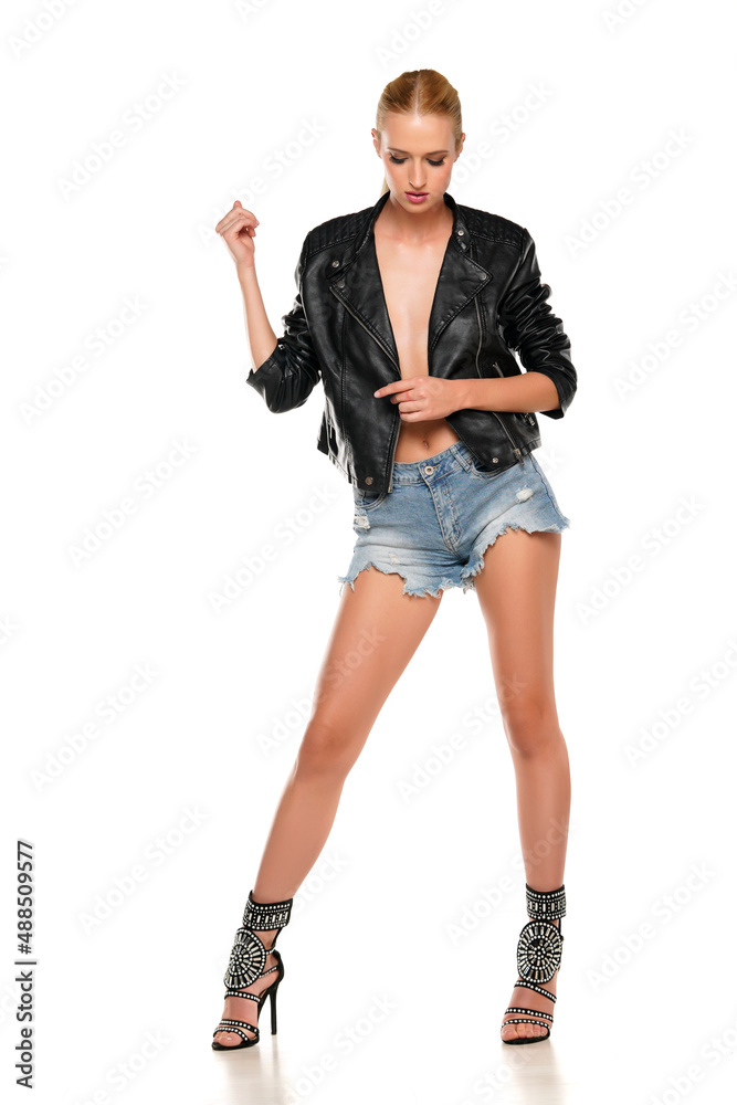 Young blond woman posing in a leather jacket and short jeans Young blond woman posing in a leather jacket and short jeans