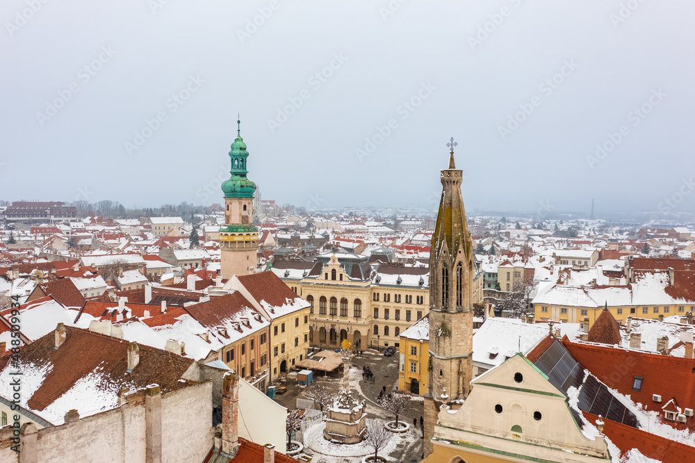 Aerial view about the main square of Sopron with the Fire tower and Goat Church. Winter cityscape with snowy rooftops.