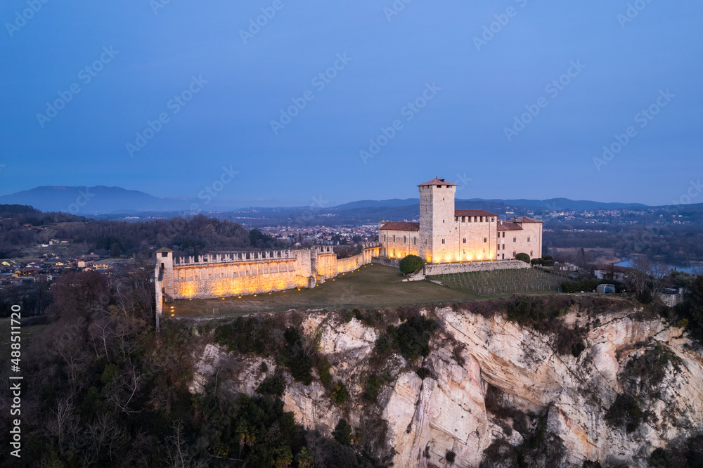 Close up aerial view of Rocca Borromea of Angera city, Varese lightened up at blue hour.