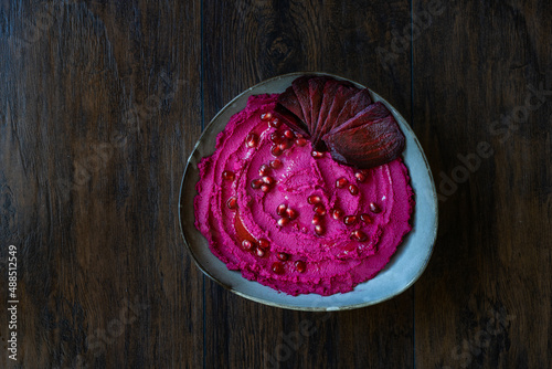 Beet Hummus in a Ceramic Bowl. Made with Beetroot and Pomegranate Seeds.