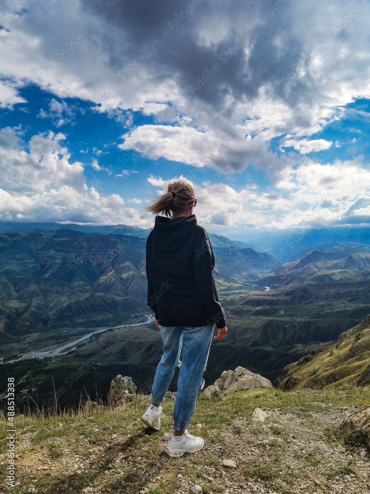 A girl on the background of a breathtaking view of the mountains in Dagestan, Caucasus. Russia 2021