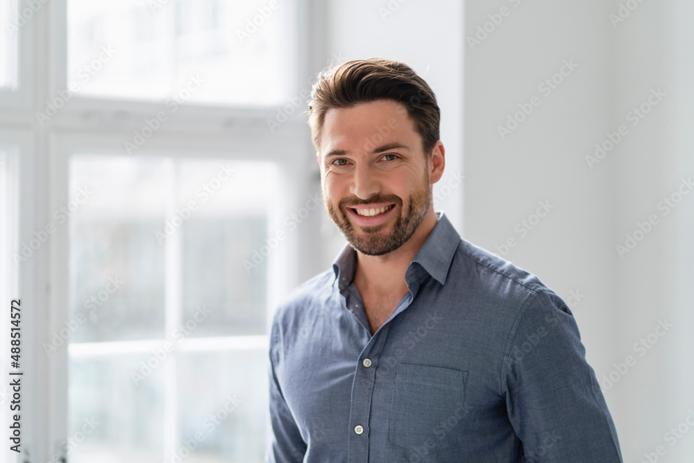 Smiling businessman at the window in office Smiling businessman at the window in office