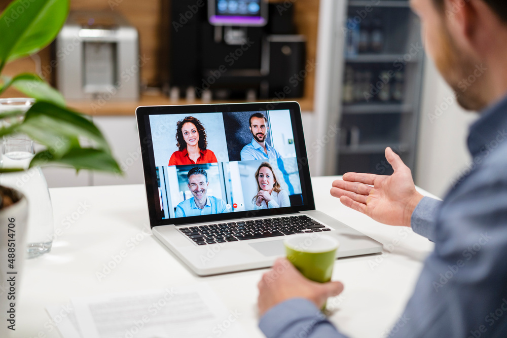 Businessman discussing with colleagues on video call at home office Businessman discussing with colleagues on video call at home office