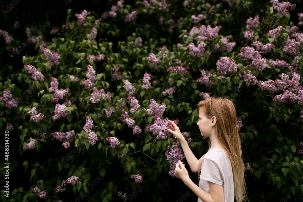 Girl touching lilac flowers in nature