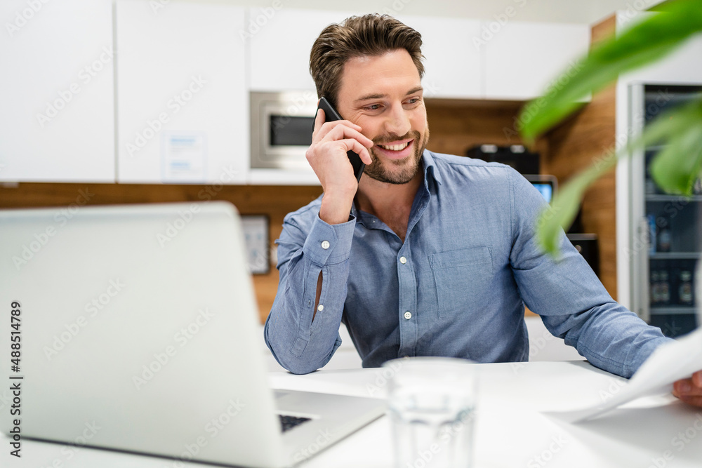 Smiling businessman talking on smart phone in office Smiling businessman talking on smart phone in office