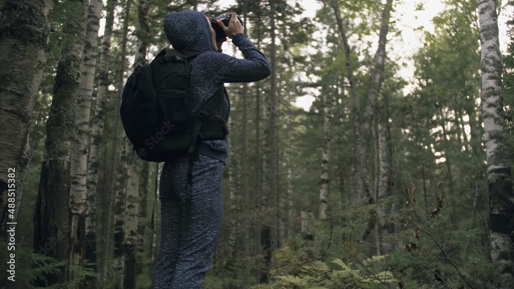 Traveler photographing scenic view in forest. One caucasian woman shooting nice magic look. Girl take photo video on dslr mirrorless camera. Professional photographer travel with backpack. Outdoor. Traveler photographing scenic view in forest. One caucasian woman shooting nice magic look. Girl take photo video on dslr mirrorless camera. Professional photographer travel with backpack. Outdoor.