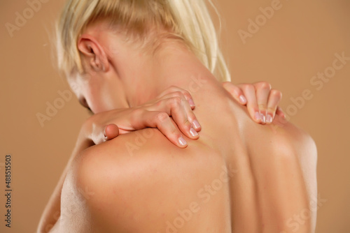 Woman with neck pain on a beige