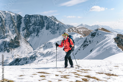 Happy woman hiking on snow covered mountain, Caucasus Nature Reserve, Sochi, Russia photo