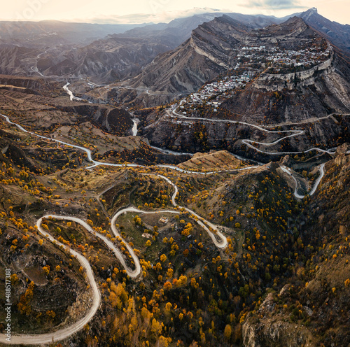 Russia, Dagestan, Gunib, Winding mountain road in autumn with Mount Gunib and village in background