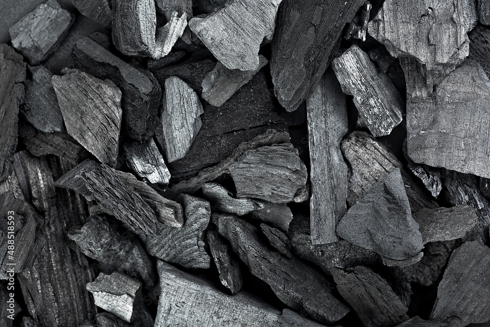 Background texture of black charcoal pieces, top view. Hardwood charcoal. Background texture of black charcoal pieces, top view. Hardwood charcoal.