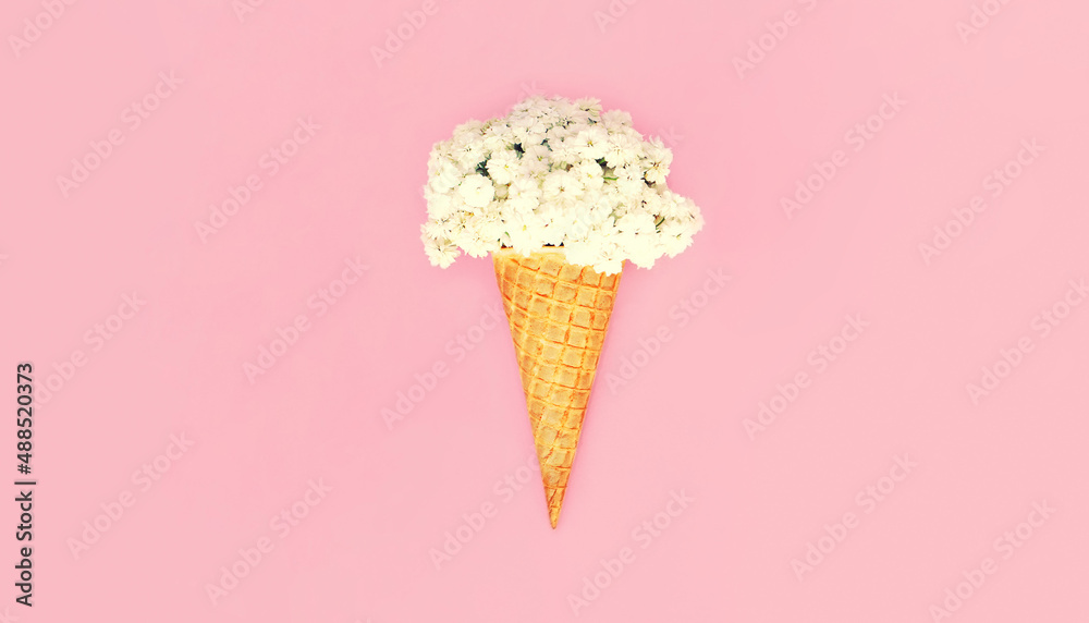 Ice cream cone with flowers on colorful pink background, top view, flat lay Ice cream cone with flowers on colorful pink background, top view, flat lay