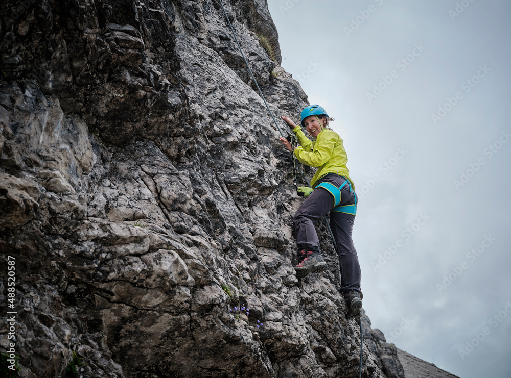 Smiling woman climbing rocky mountain Smiling woman climbing rocky mountain
