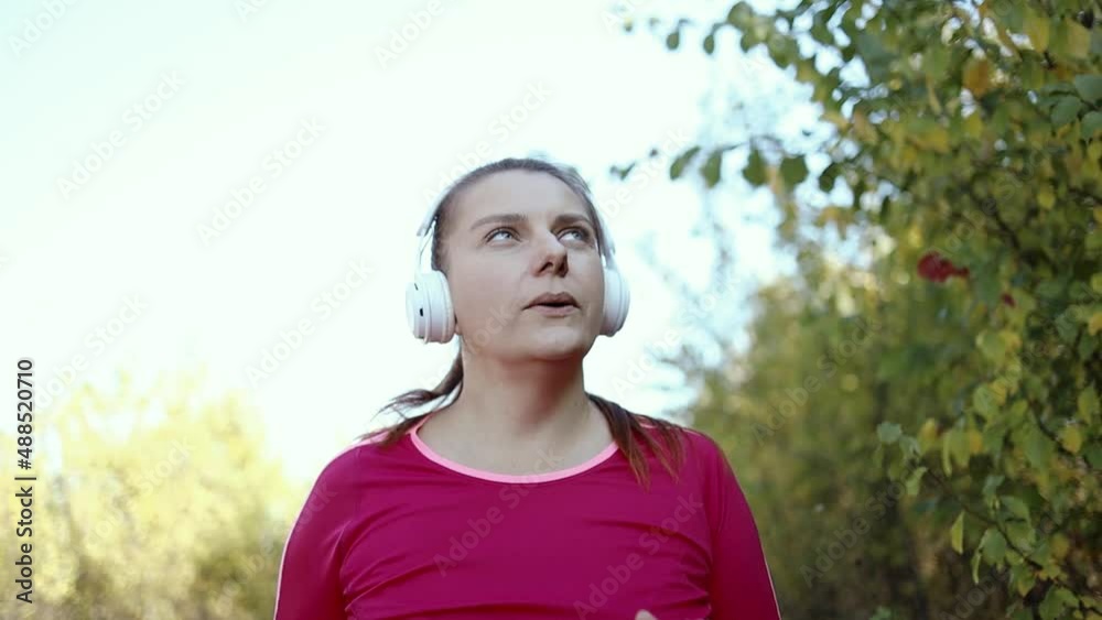 Active run woman with white headphones running in nature autimn fall. Fitness healthy lifestyle. Workout, wellbeing and sport girl concepts Active run woman with white headphones running in nature autimn fall. Fitness healthy lifestyle. Workout, wellbeing and sport girl concepts