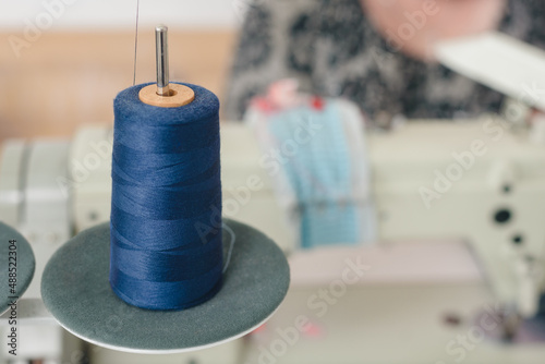 Blue bobbin of sewing thread in modern fashion atelier photo