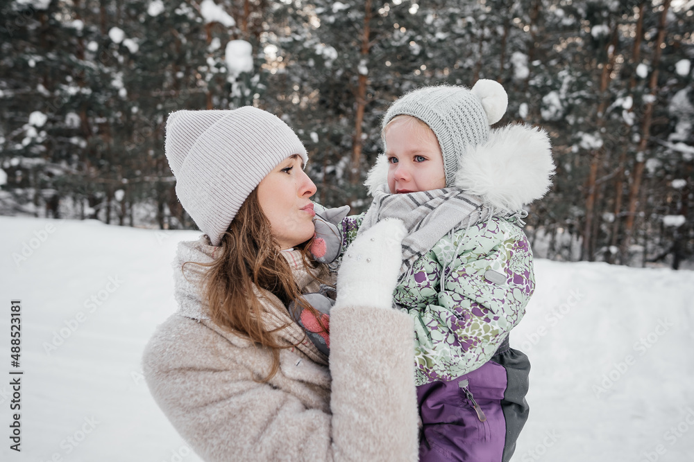 the baby cries and is sad, the mother holds the child in her arms and soothes. High quality photo