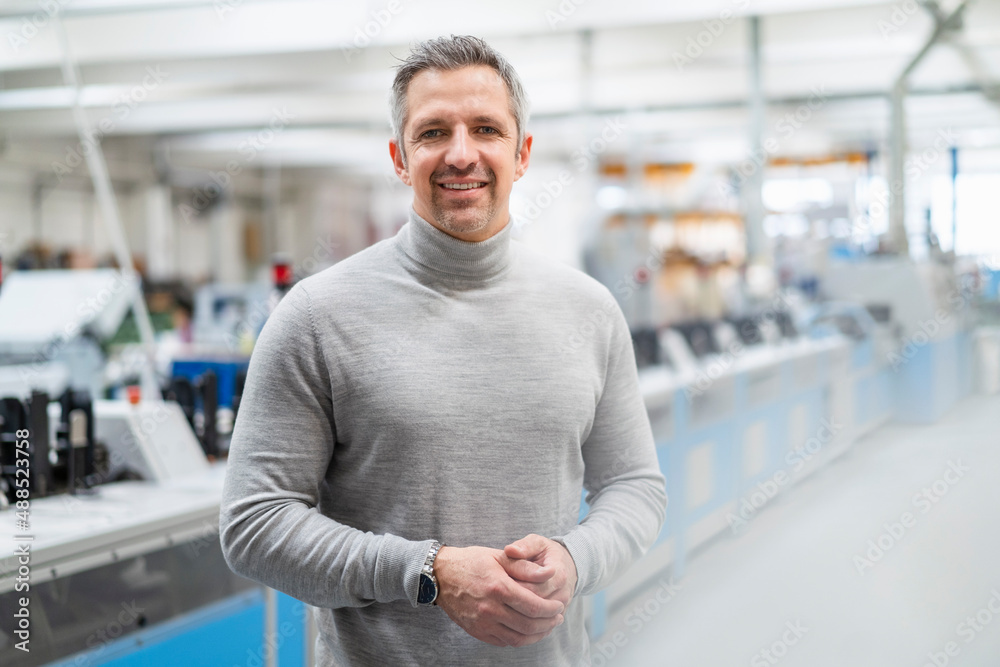 Smiling businessman with gray hair in factory Smiling businessman with gray hair in factory