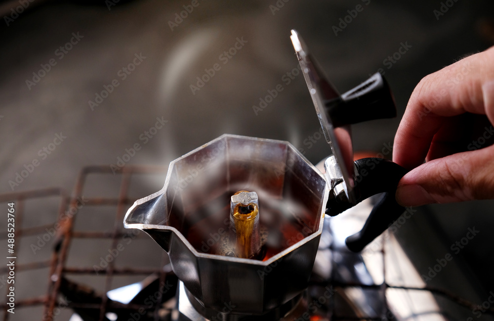 Coffee beans in Moka pot and smoke.Brewing black moka coffee using moka coffee maker Coffee beans in Moka pot and smoke.Brewing black moka coffee using moka coffee maker