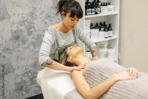 Therapist giving massage to woman at aesthetic clinic photo