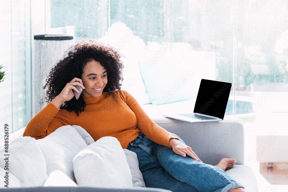 Smiling woman talking on mobile phone in living room Smiling woman talking on mobile phone in living room