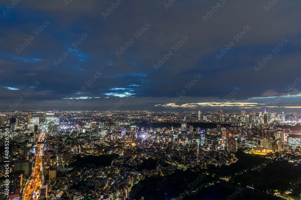 Japan, Kanto Region, Tokyo, Cloudy sky over illuminated city downtown at night Japan, Kanto Region, Tokyo, Cloudy sky over illuminated city downtown at night