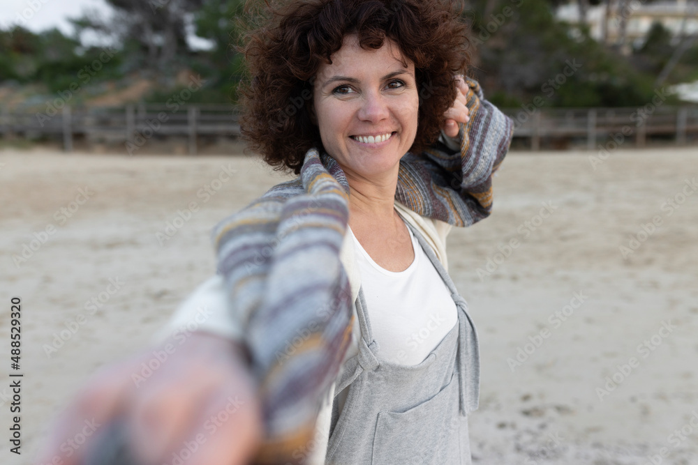 Smiling woman standing on sand at beach Smiling woman standing on sand at beach
