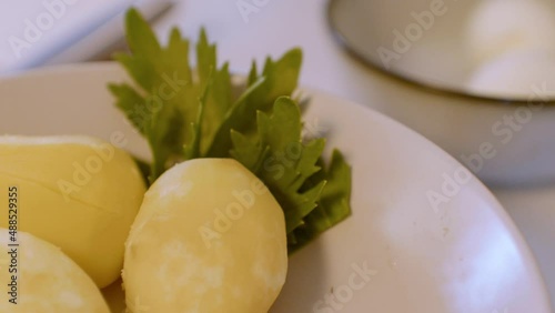 Slicing boiled potatoes. Ingredients for salad.