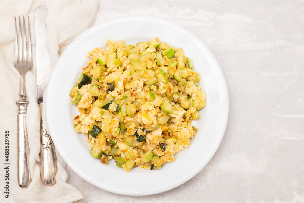 scrambled egg with zucchini on white small plate scrambled egg with zucchini on white small plate