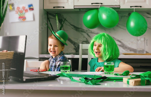 Children communicate online via a laptop on the Patrick's Day holiday. Traditions, technologies, holidays concept.