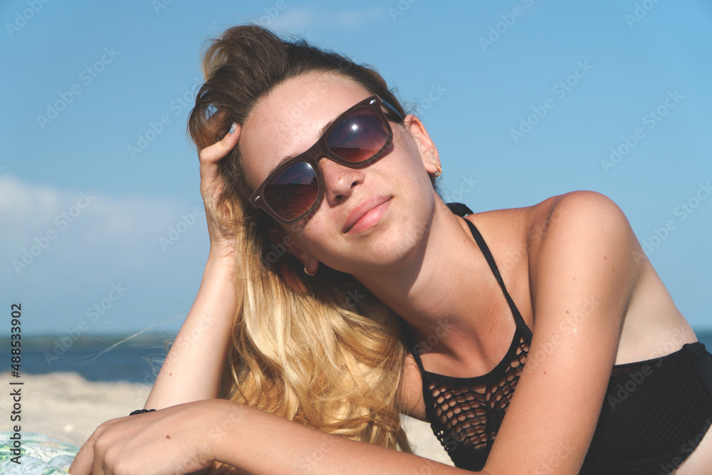 Faces of a beautiful girl in glasses on the seashore against the blue sky. Faces of a beautiful girl in glasses on the seashore against the blue sky.