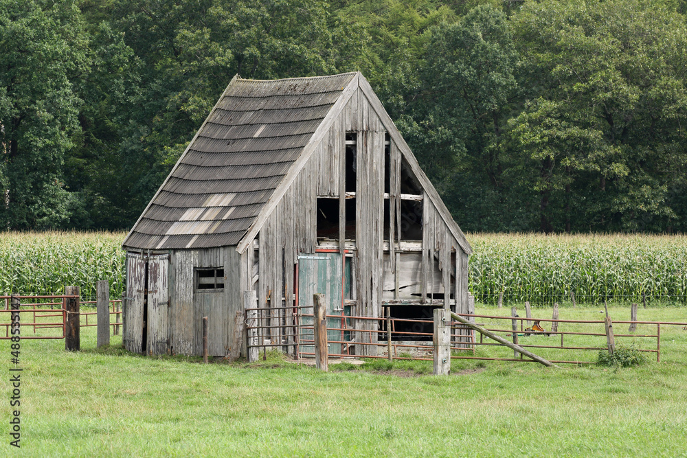 Obraz premium An old and crooked barn in a meadow 