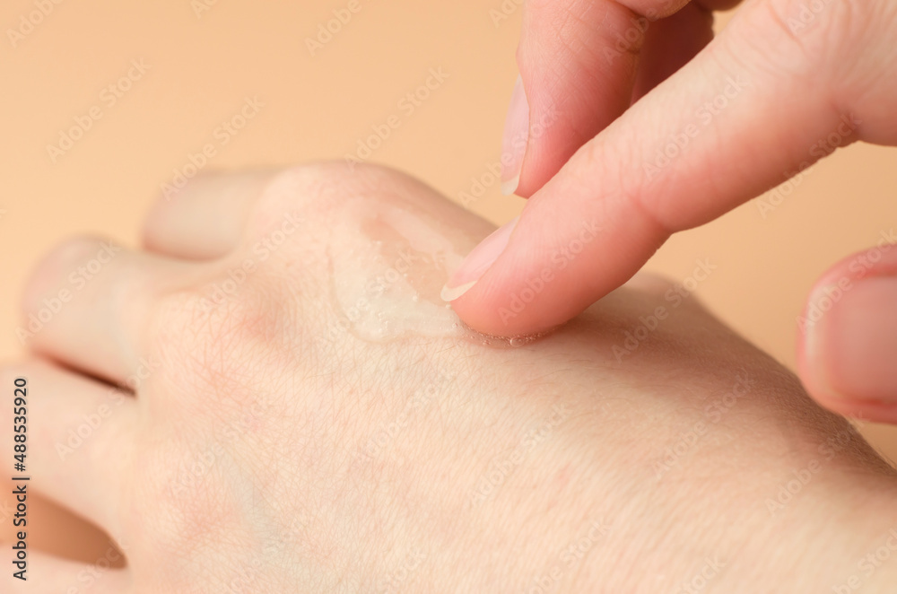 Transparent gel on a female hand. Woman applying moisturizing gel on her wrist Transparent gel on a female hand. Woman applying moisturizing gel on her wrist