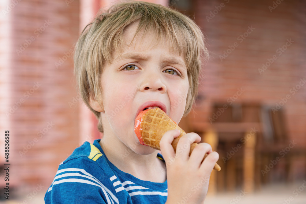 The blond guy dreamily eats ice cream The blond guy dreamily eats ice cream