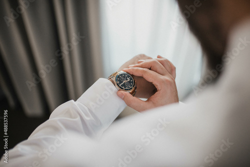 Businessman checking the time on his wrist watch.