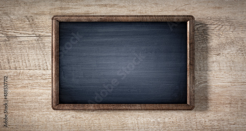 Empty chalkboard with wooden frame isolated on wooden background - 3D illustration