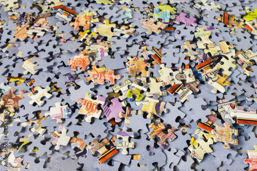 Background of scattered colorful puzzle pieces. A bunch of jigsaw puzzle pieces.