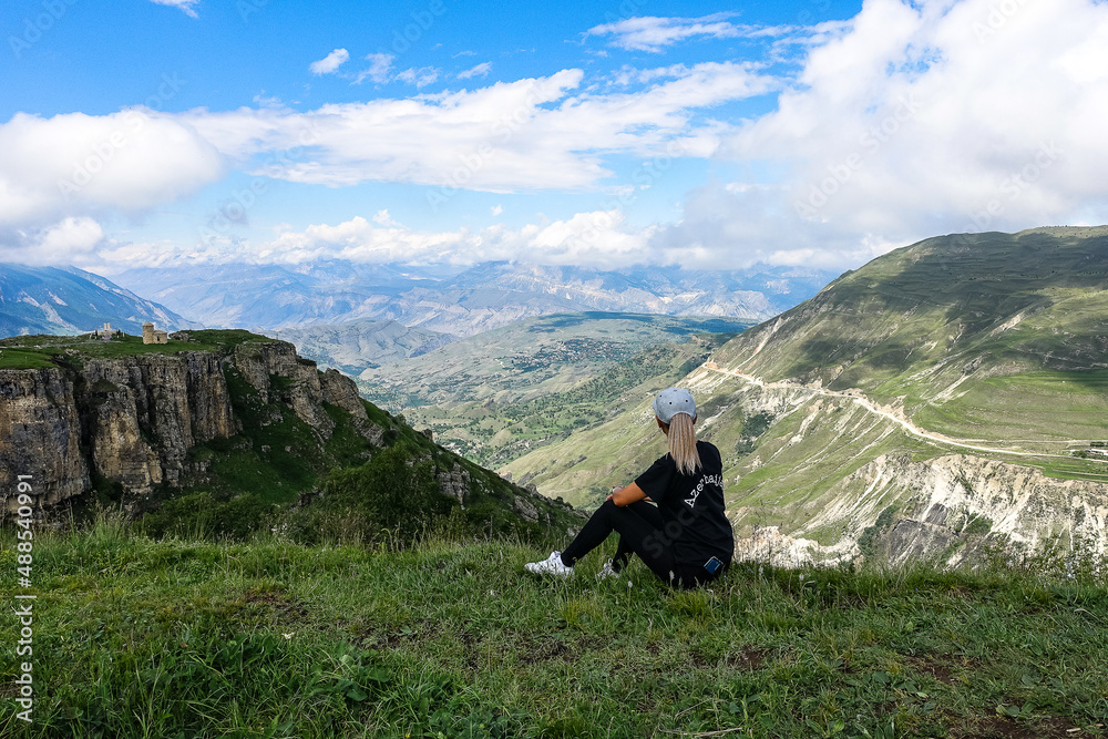 Fototapeta premium A girl on the background of a view of the Matlas plateau. Khunzakhsky district. Dagestan Russia 2021