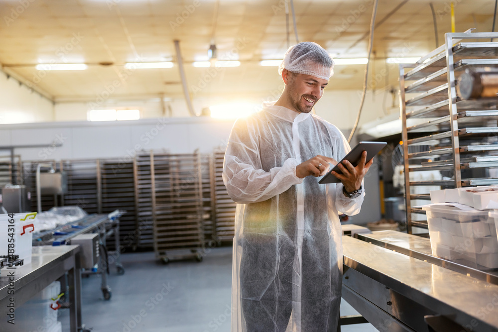 Food factory inspector using a tablet to check on the quality and quantity of products. Food factory inspector using a tablet to check on the quality and quantity of products.